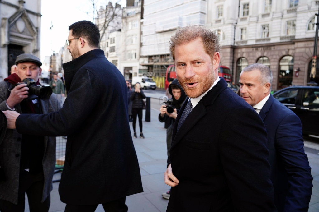 Harry look at press just before he bumps into a photographer, seen left.