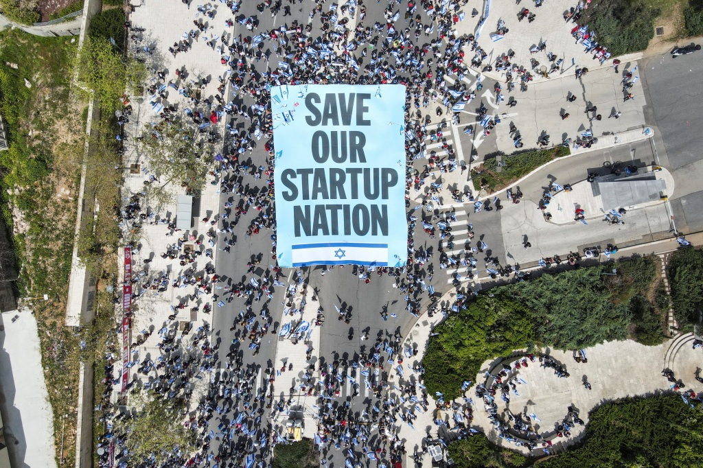 protesters with a "Save our startup nation" sign.