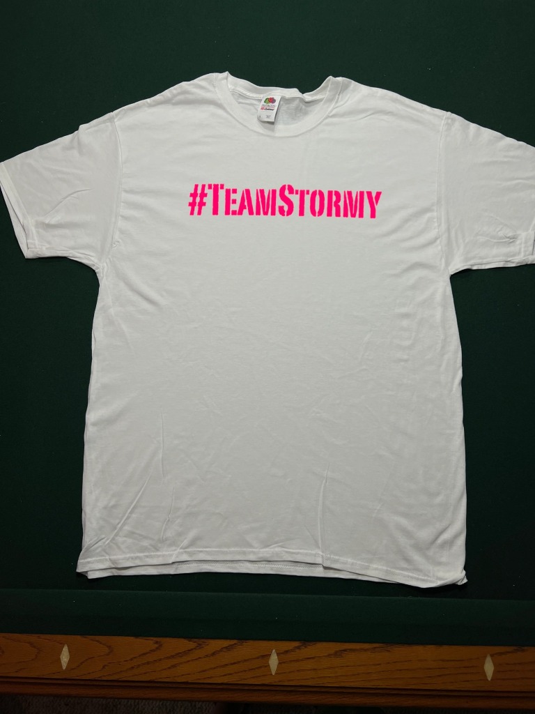 White t-shirt with #TeamStory written in pink across front