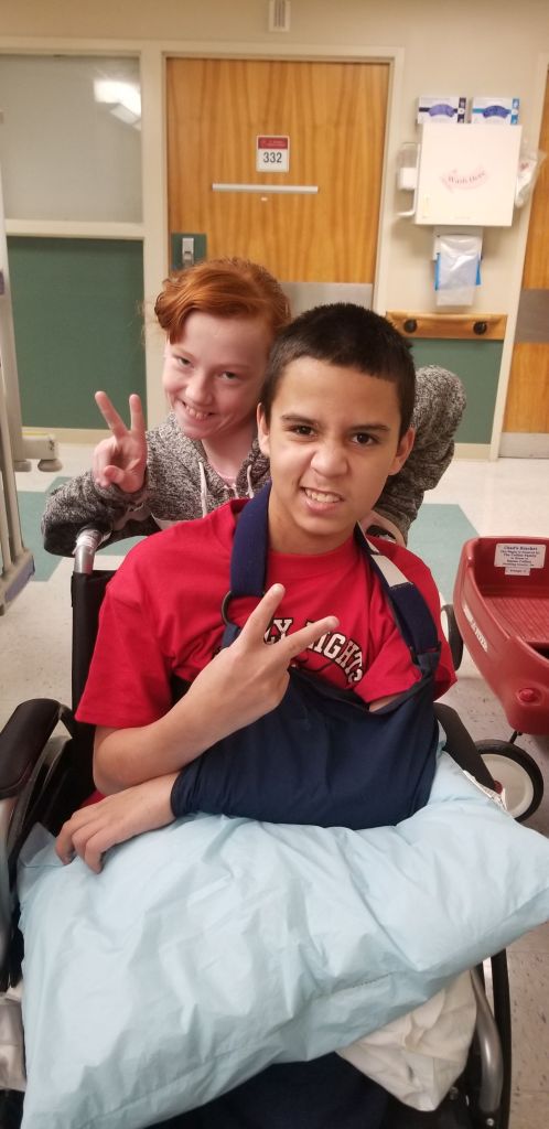 Zach Corona in a wheelchair with his sister Katie Amos.