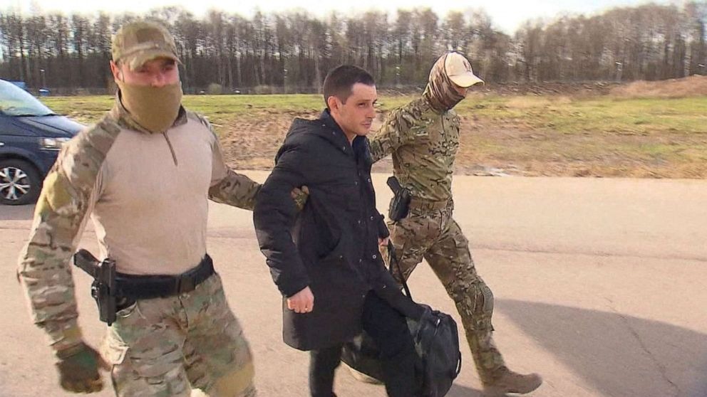 Former U.S. Marine Trevor Reed, who was detained in 2019 and accused of assaulting police officers, is escorted to a plane by Russian service members as part of a prisoner swap between the U.S. and Russia, in Moscow, April 27, 2022.