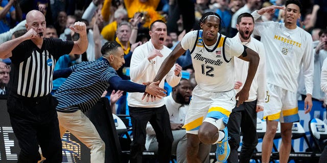 Marquette forward Olivier-Maxence Prosper (12) celebrates three-point basket with head coach Shaka Smart in the second half of a second-round college basketball game against Michigan State in the men's NCAA Tournament in Columbus, Ohio, Sunday, March 19, 2023. 