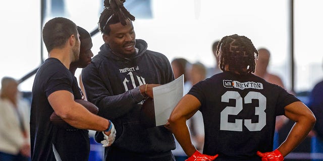 Former NFL and Auburn quarterback, Cam Newton, talks with receivers during Auburn Pro Day, Tuesday, March 21, 2023, in Auburn, Ala. 