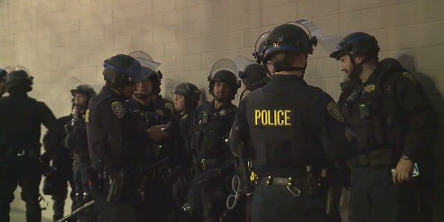 Law enforcement officers stop unrest outside a venue at UC Davis where protesters attempted to stop a speaking event. 