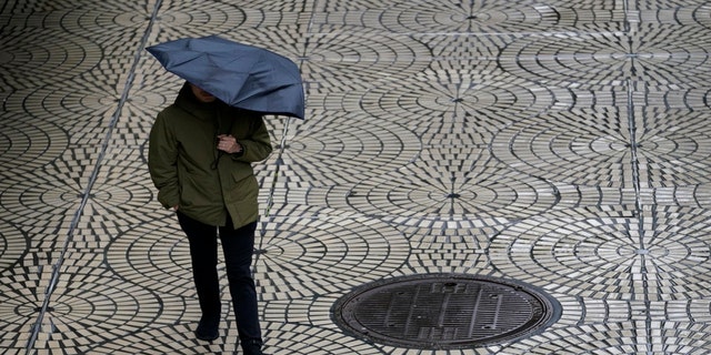 A pedestrian carries an umbrella while walking in San Francisco, Tuesday, March 14, 2023.