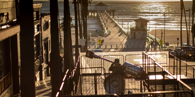 Workers with BrewCo, a craft beer hall serving food on Manhattan Beach Boulevard, works on dismantling their outdoor dining decks, in Manhattan Beach, California, March 1, 2023, a day after California's COVID-19 emergency officially ended. 