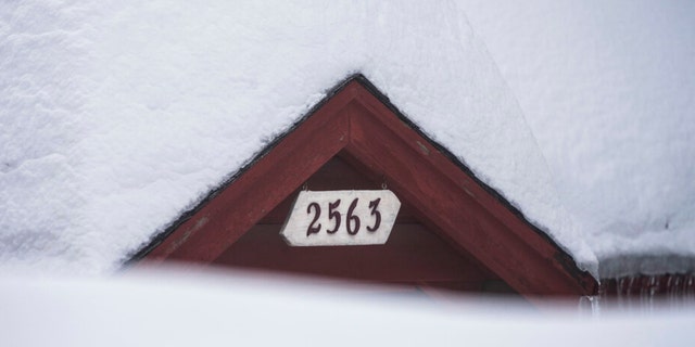 Snow is piled up on a home in Running Springs, Calif., Tuesday, Feb. 28, 2023. 