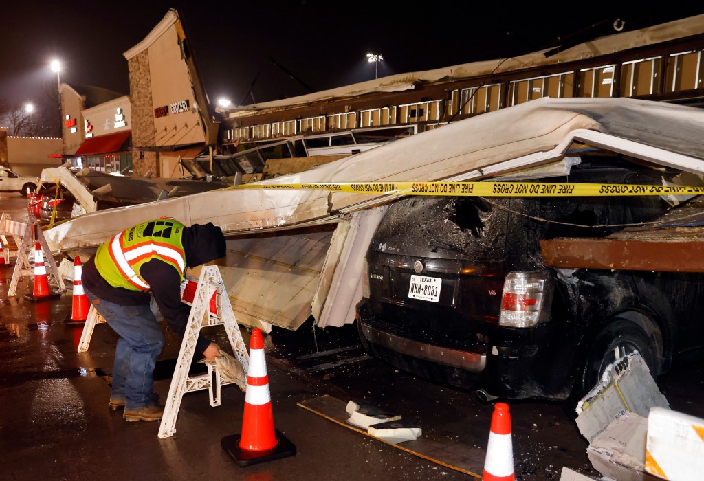 The roof of a grocery store peeled off and landed on vehicles in the parking lot during the storm in Little Elm, Texas on March 2, 2023.