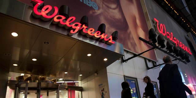 Shoppers walk by a Walgreens in New York.