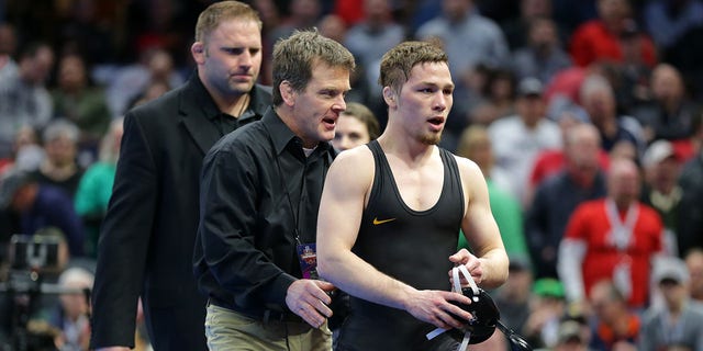 Spencer Lee of the Iowa Hawkeyes is congratulated by assistant head coach Terry Brands after winning his first-place match during session six of the NCAA.