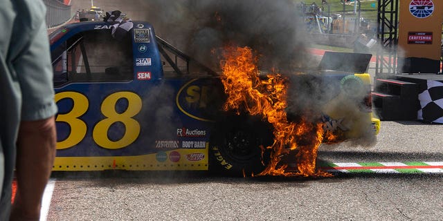 Fire spreads over Zane Smith's truck following his celebratory burnout after winning a NASCAR Truck Series auto race, Saturday, March 25, 2023, in Austin.