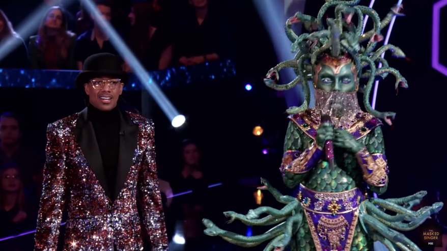 Nick Cannon stands next to the Medusa singer on Wednesday's episode of "The Masked Singer."