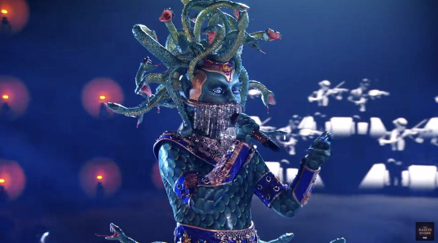 The masked performer disguised as Medusa sings during the show.