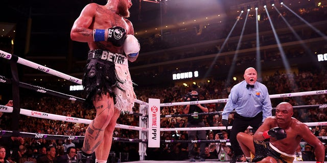 Jake Paul (L) reacts after knocking down Anderson Silva of Brazil during their cruiserweight bout at Gila River Arena on October 29, 2022 in Glendale, Arizona.