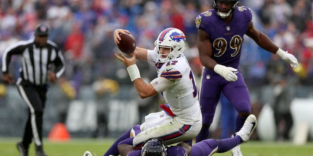 Josh Allen of the Buffalo Bills runs with the ball while being tackled by Jason Pierre-Paul of the Ravens on Oct. 2, 2022, in Baltimore.