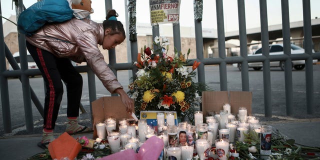 A girl lights candle during a vigil for the victims of a fire at an immigration detention center that killed dozens in Ciudad Juarez, Mexico, Tuesday, March 28, 2023. According to Mexican President Andres Manuel Lopez Obrador, migrants fearing deportation set mattresses ablaze at the center, starting the fire.