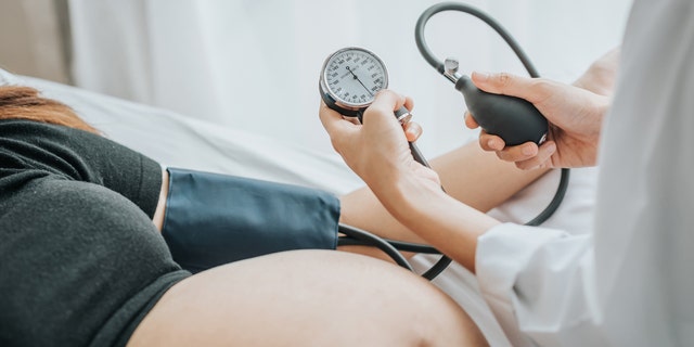 A pregnant woman is shown during an exam. Heart disease is the leading cause of maternal mortality in the U.S.