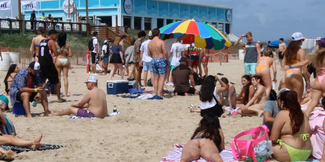 Groups of Spring Breakers huddle together on the beach in South Padre. Lil Wayne and Steve Aoki are just some of the artist to visit the island during college spring break. 