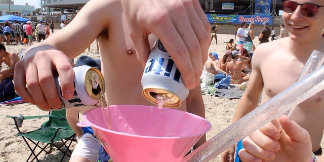 A group of college boys get ready to show off their beer funneling skills on the beaches of South Padre Island. 