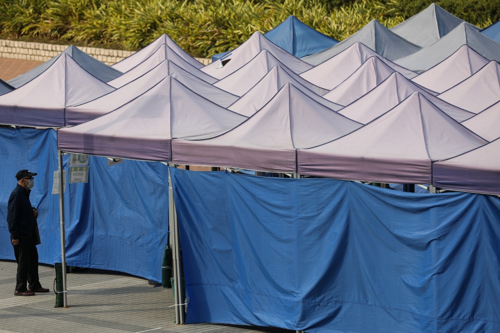 A man wears a face mask while lining up for COVID test in a makeshift testing center in Hong Kong.