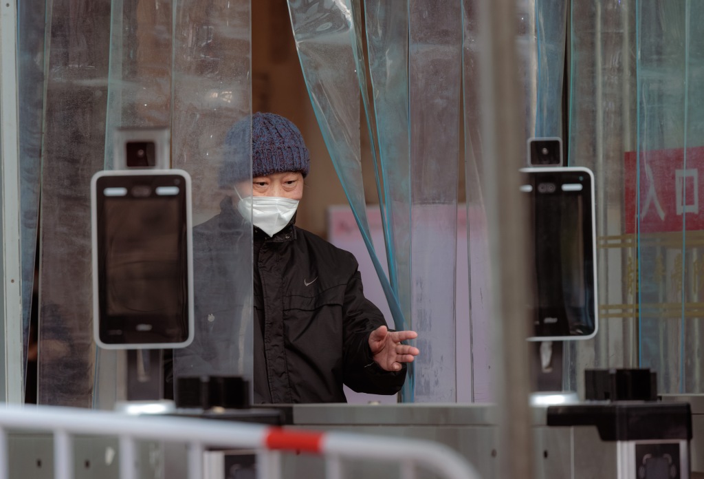 A man exits a hospital past temperature scanners no longer in use in Shanghai, China. 