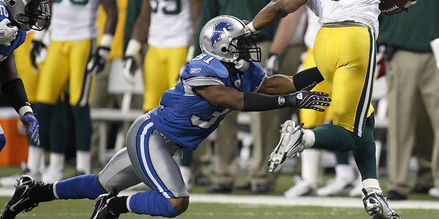 Koren Robinson #81 of the Green Bay Packers tries to get around the tackle of Stanley Wilson #31 of the Detroit Lions at Ford Field November 22, 2007 in Detroit, Michigan. Green Bay won the game 37-26.  