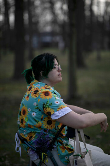 Cody, wearing a shirt printed with sunflowers and looking out into the distance.