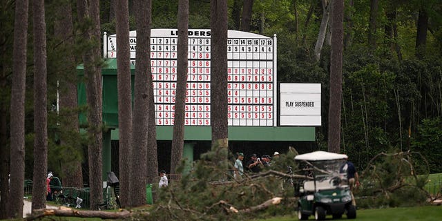 A sign that says "Play Suspended" on the leaderboard near fallen trees on the 17th hole during the second round of the 2023 Masters Tournament at Augusta National Golf Club April 7, 2023, in Augusta, Ga. 