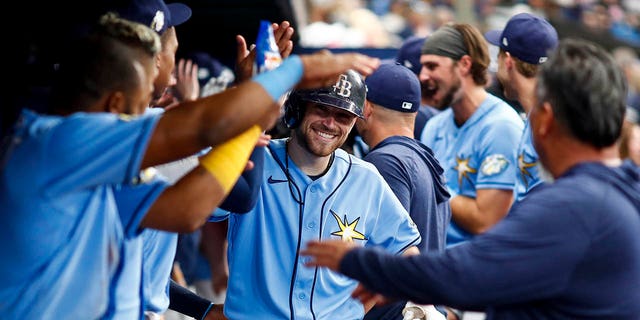 The Tampa Bay Rays' Brandon Lowe, center, celebrates with teammates in the dugout after hitting a home run during the sixth inning against the Oakland Athletics at Tropicana Field in St Petersburg, Florida, on Saturday.