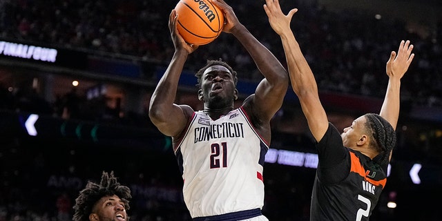 Connecticut forward Adama Sanogo scores past Miami guard Isaiah Wong during the second half of a Final Four game in the NCAA Tournament April 1, 2023, in Houston. 