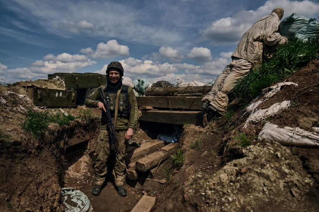 A Ukrainian soldier smiles standing in a trench on the frontline in the village of Donetsk region of Ukraine.