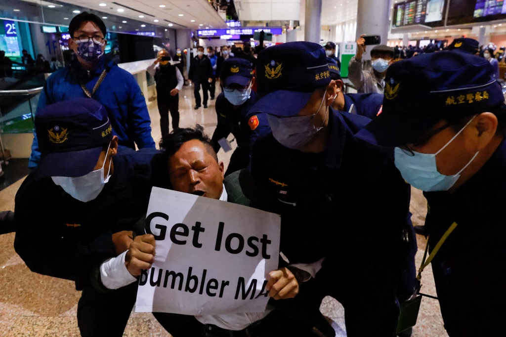 A protester being escorted out by the police before former Taiwan president Ma Ying-jeou arrives in Taoyuan, Taiwan on April 7, 2023.