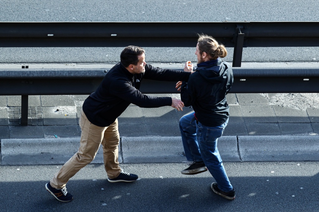 A car driver confronts an activist filming the "Letzte Generation" (Last Generation) protest for climate councils in Berlin, Germany, on April 24, 2023. 