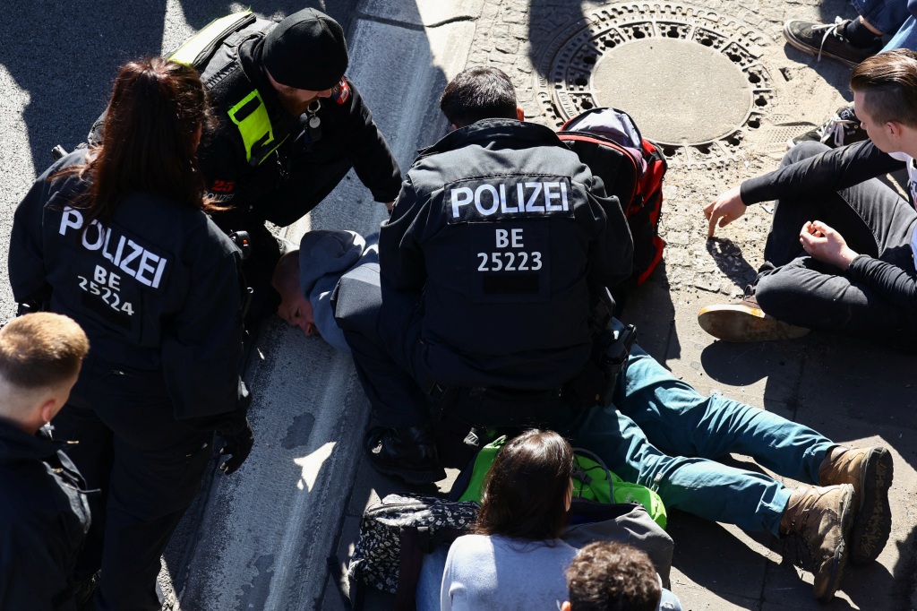 Police officers detain an activist during the climate protest on the highway in Berlin, Germany, on April 24, 2023. 