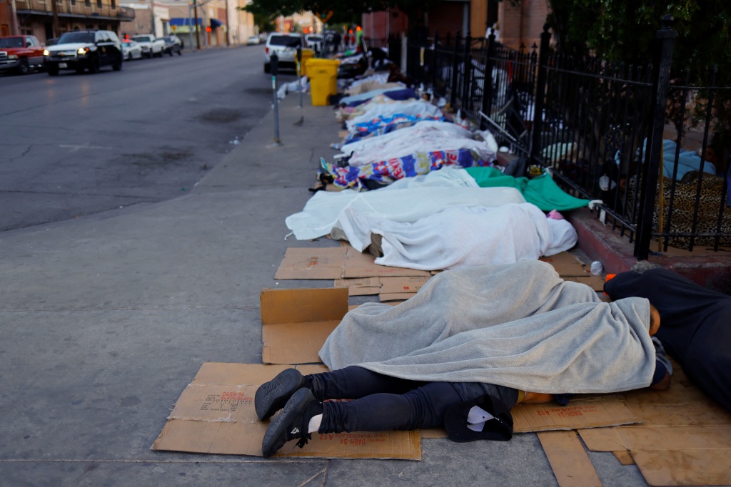Migrants sleep outside a church, as shelters have run out of space due to the arrival of hundreds of migrants, in downtown El Paso