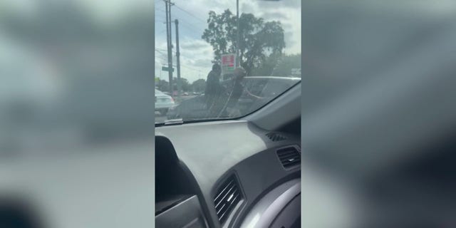 In video posted by the Florida Highway Patrol, the man can be heard yelling "get out of the car!" and the woman can be seen punching the car's window.