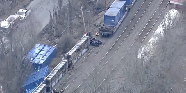 Officials walk near the scene of a freight train derailment, Thursday, March 23, 2023, in Ayer, Mass. 