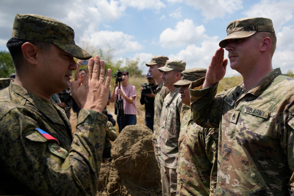 Philippine Army Artillery Regiment Commander Anthony Coronel, left, returns a salute from a US soldier during a joint military drill called Salaknib at Laur, Nueva Ecija province, northern Philippines on March 31, 2023.