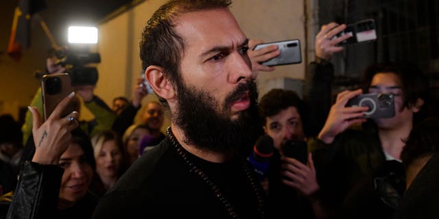 Young fans and media surround Andrew Tate as he leaves a police detention facility in Bucharest, Romania, after his release from prison on Friday March 31, 2023. An official on Friday said Tate, the divisive internet personality who has spent months in a Romanian jail on suspicion of organized crime and human trafficking, has won an appeal to replace his detention with house arrest.