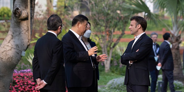 Chinese President Xi Jinping, second left, and French President Emmanuel Macron talk in the garden of the Guandong province governor's residence, in Guangzhou, China, Friday, April 7, 2023. 