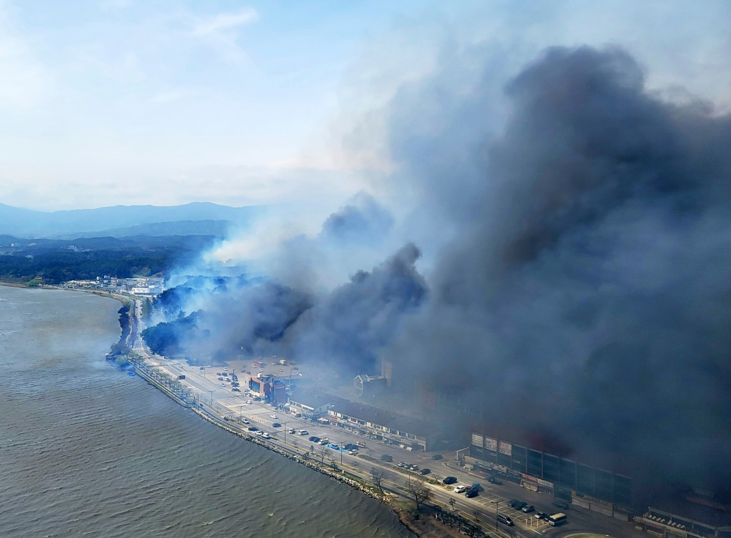 Smoke from a wildfire covers near a lake in Gangneung, South Korea, on April 11, 2023. 