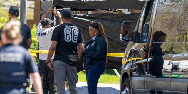 Metropolitan Police Department officers investigate the scene were four people were shot in front of Stewart Funeral Home, Tuesday, April 11, 2023, in D.C.