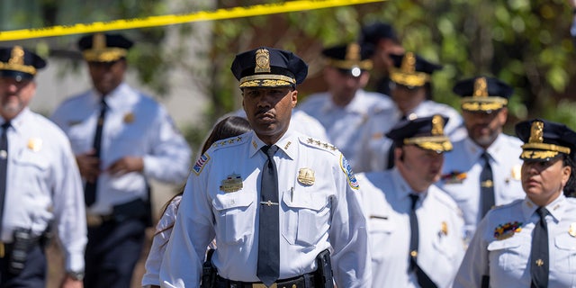 Metropolitan Police Chief Robert Contee III walks to speak with reporters Tuesday, April 11, 2023, in Washington after a shooting outside a funeral home.