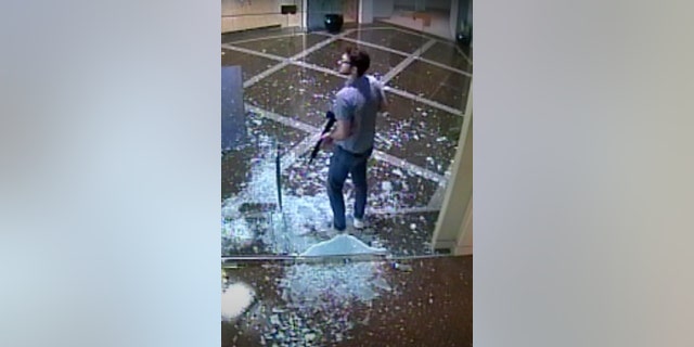 This surveillance video provided by the Louisville Metro Police Department shows bank employee Connor Sturgeon, 25, carrying an AR-15 assault-style rifle after opening fire at Old National Bank, in Louisville, Ky., Monday, April 10, 2023. 