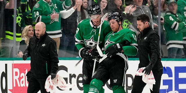 Dallas Stars' Joe Pavelski, second from right, is helped off the ice by Mason Marchment and staff after suffering an unknown injury in the second period of Game 1 of an NHL hockey Stanley Cup first-round playoff series against the Minnesota Wild, Monday, April 17, 2023, in Dallas.