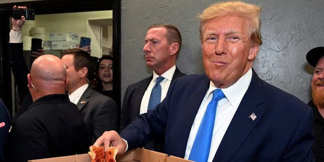 Former President Donald Trump eats a slice of pizza in Florida