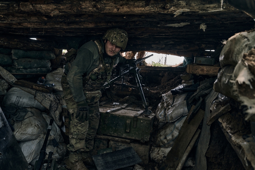 A Ukrainian soldier prepares to fire his machine gun in a dugout on the frontline in the village of Donetsk, Ukraine. 