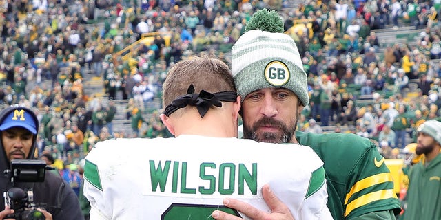 Aaron Rodgers and Zach Wilson embrace