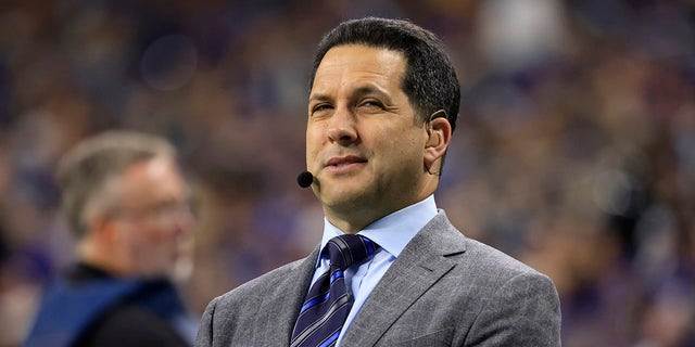 Adam Schefter looks on field