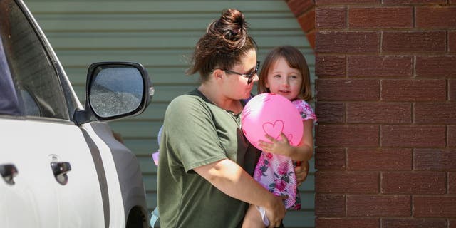 Cleo Smith, right, is carried inside a friend's house by her mother on Nov. 4, 2021 in Carnarvon, Australia.